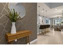 Bright entryway with geometric wallpaper, console table, and view of the dining area at 3937 Lana Ave, Davenport, FL 33897