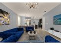 Spacious living room with blue velvet sofas, a coffee table, and a large TV at 3937 Lana Ave, Davenport, FL 33897