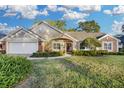 Beautiful two-story home with landscaped lawn and attached two-car garage at 5011 Winwood Way, Orlando, FL 32819
