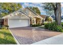Brick and shingle home with a large driveway and lush landscaping at 5011 Winwood Way, Orlando, FL 32819