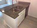 Kitchen island with granite countertop and double sink at 5291 Images Cir # 204, Kissimmee, FL 34746