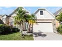 Charming two-story home featuring a well-manicured lawn, a brick-paved driveway, and lovely palm trees at 1108 Darnaby Way, Orlando, FL 32824