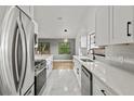 Bright kitchen with white shaker cabinets, quartz countertops, and stainless steel appliances at 1395 Kenneth Ave, Casselberry, FL 32707