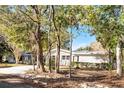 Mid-century home nestled among lush trees, showcasing a brick facade and carport at 1642 Athens St, Lakeland, FL 33803