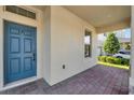 Covered porch with a blue door and brick pavers at 16685 Oakboro St, Winter Garden, FL 34787