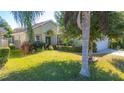 Well-maintained house with a green exterior, lush landscaping, and a two-car garage at 5649 Magnolia Bloom Ter, Oviedo, FL 32765
