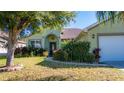 House exterior showcasing a manicured lawn, entryway, and attached garage at 5649 Magnolia Bloom Ter, Oviedo, FL 32765