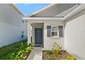 Front entrance with gray door, shutters, and walkway at 640 Reggie Rd, Winter Haven, FL 33884