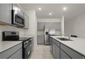 Modern kitchen with gray cabinets, stainless steel appliances, and quartz countertops at 640 Reggie Rd, Winter Haven, FL 33884