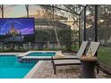 Relax by the pool and hot tub with a mounted TV under a screened enclosure for ultimate outdoor entertainment at 1427 Wexford Way, Davenport, FL 33896