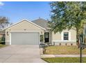 Inviting single-story home with lush front lawn, two-car garage, and decorative garden bed at entry at 164 Pergola Pl, Ormond Beach, FL 32174