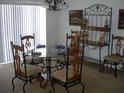 Dining room with glass-top table, wrought iron chairs, and decorative wall art at 603 Keppel Ct, Kissimmee, FL 34746