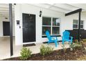 Inviting front porch with blue chairs and a black door at 992 Carnation Dr, Winter Park, FL 32792