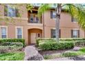 Front entrance of a two-story townhome with landscaping and brick walkway at 120 Palermo St, Davenport, FL 33897
