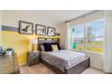 Cozy bedroom with a double bed, yellow accent wall, and large window at 1324 Hanoverian Dr, Lake Alfred, FL 33850