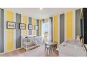 Bedroom with crib, changing table, and yellow and gray striped walls at 1324 Hanoverian Dr, Lake Alfred, FL 33850