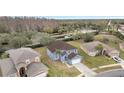 Aerial view of a two-story house with a large backyard and surrounding neighborhood at 2556 Volta Cir, Kissimmee, FL 34746