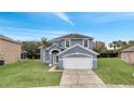 Two-story house with gray siding, two-car garage, and a palm tree at 2556 Volta Cir, Kissimmee, FL 34746