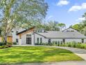 Modern home with a stylish entryway and manicured lawn at 304 E Greentree Ln, Lake Mary, FL 32746