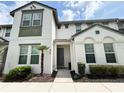 Well-maintained townhome with front yard with tidy landscaping and a gray front door at 430 Captiva Dr, Davenport, FL 33896