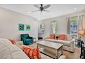 Living room with light colored sofas, coffee table, and teal accent chair at 8049 Lost Shaker Ln, Kissimmee, FL 34747
