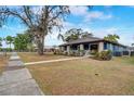 Blue house with stone accents, landscaping, and a walkway at 100 E Cypress St, Davenport, FL 33837