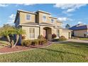 Two-story house with a red door, landscaping, and a paved driveway at 11113 Scenic Vista Dr, Clermont, FL 34711