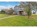 Two-story house with green siding, stone accents, and a manicured lawn at 1942 J Lawson Blvd, Orlando, FL 32824