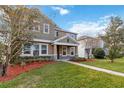 Two-story house with green siding, stone accents, and a manicured lawn at 1942 J Lawson Blvd, Orlando, FL 32824