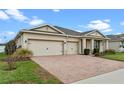 Two-car garage and well-maintained landscaping enhance curb appeal at 2249 Palmetum Loop, Apopka, FL 32712