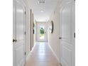 Neutral-toned hallway with tile flooring and access to multiple rooms at 2917 Hudson Hammock Way, Saint Cloud, FL 34773