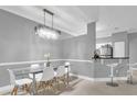 Modern dining room with breakfast bar, glass table, and white chairs at 3361 S Kirkman Rd # 811, Orlando, FL 32811