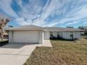 Front view of a single-story house with a white garage door at 4465 Ne 2Nd Ct, Ocala, FL 34479
