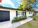 Updated home with white brick exterior, black garage door, and green front door at 4732 Lighthouse Cir, Orlando, FL 32808