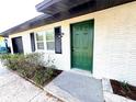 Front entrance of a renovated home with a green door and white brick at 4732 Lighthouse Cir, Orlando, FL 32808