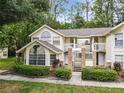 Inviting exterior of condo building featuring a two-story layout, lush landscaping, and multiple levels of balconies at 5003 Laguna Bay Cir # 16, Kissimmee, FL 34746
