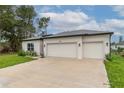 Close up showcasing this house with attached three-car garage and well-manicured lawn at 5381 Sw 129Th Pl, Ocala, FL 34473