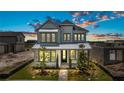 Two-story home at dusk featuring a modern facade, well-manicured landscaping, and a welcoming front porch at 9819 Gobat Aly, Orlando, FL 32827