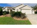 Tan house with double garage and landscaping at 2530 Saffron Ln, The Villages, FL 32162