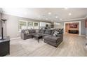 Spacious living room with gray sectional, light wood floors, and an open layout to the kitchen at 2803 E Pine St, Orlando, FL 32803
