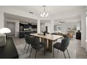 Dining area features a modern chandelier and seating for six, adjacent to kitchen and living room at 4032 Prairie Reserve Blvd, Orlando, FL 32824