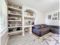 Living room with sectional sofa, built in shelving, and hardwood floors at 7350 Westpointe Blvd # 224, Orlando, FL 32835