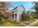 Two-story house with light blue siding, landscaping, and a front porch at 8763 Laureate Blvd, Orlando, FL 32827