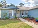 Inviting home exterior featuring a well-kept lawn and a welcoming front porch with decorative plants at 2122 King Richards Ct, Orange City, FL 32763