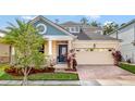 Two-story house with a neutral color scheme and a welcoming front porch at 2487 Empress Dr, Kissimmee, FL 34741
