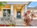 Front porch with a stone facade, a green door, and a white bench at 2487 Empress Dr, Kissimmee, FL 34741