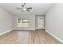 Spacious living room with vinyl plank flooring, large window, and ceiling fan at 25 Locust Loop Ln, Ocala, FL 34472