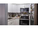 Cozy kitchen featuring updated white cabinets and stainless steel appliances at 293 Scottsdale Sq # 293, Winter Park, FL 32792