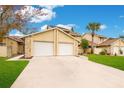 Tan two-story townhouses with two-car garages and manicured lawns at 545 Brown Pelican Dr, Daytona Beach, FL 32119