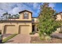 Tan two-story townhome with two-car garage, and landscaped front yard at 8145 Roseville Blvd, Davenport, FL 33896